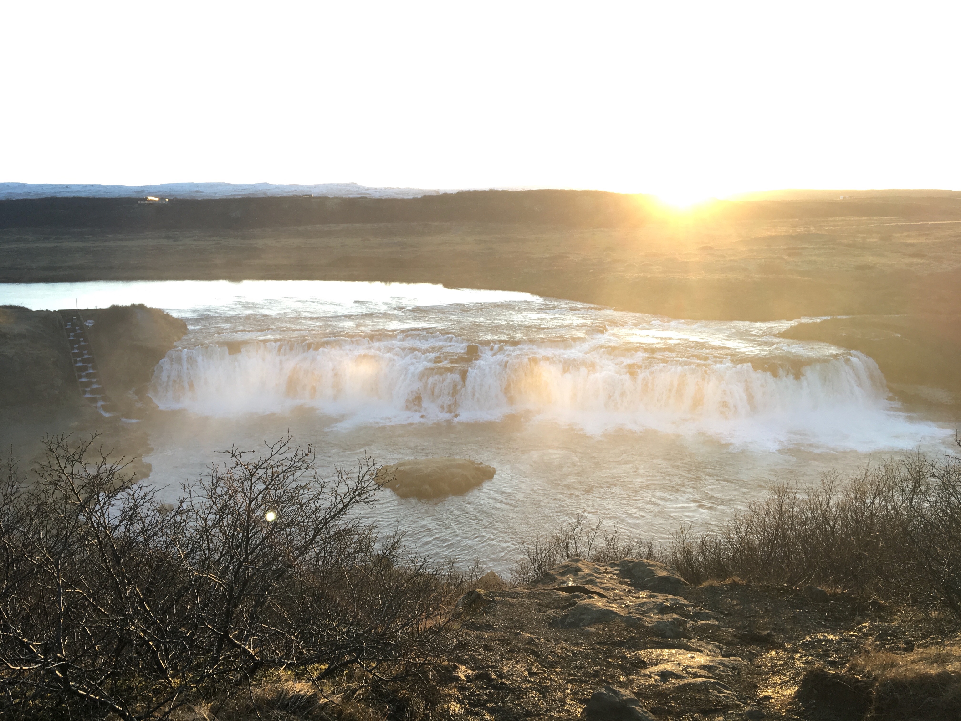 Large waterfall with sun in background