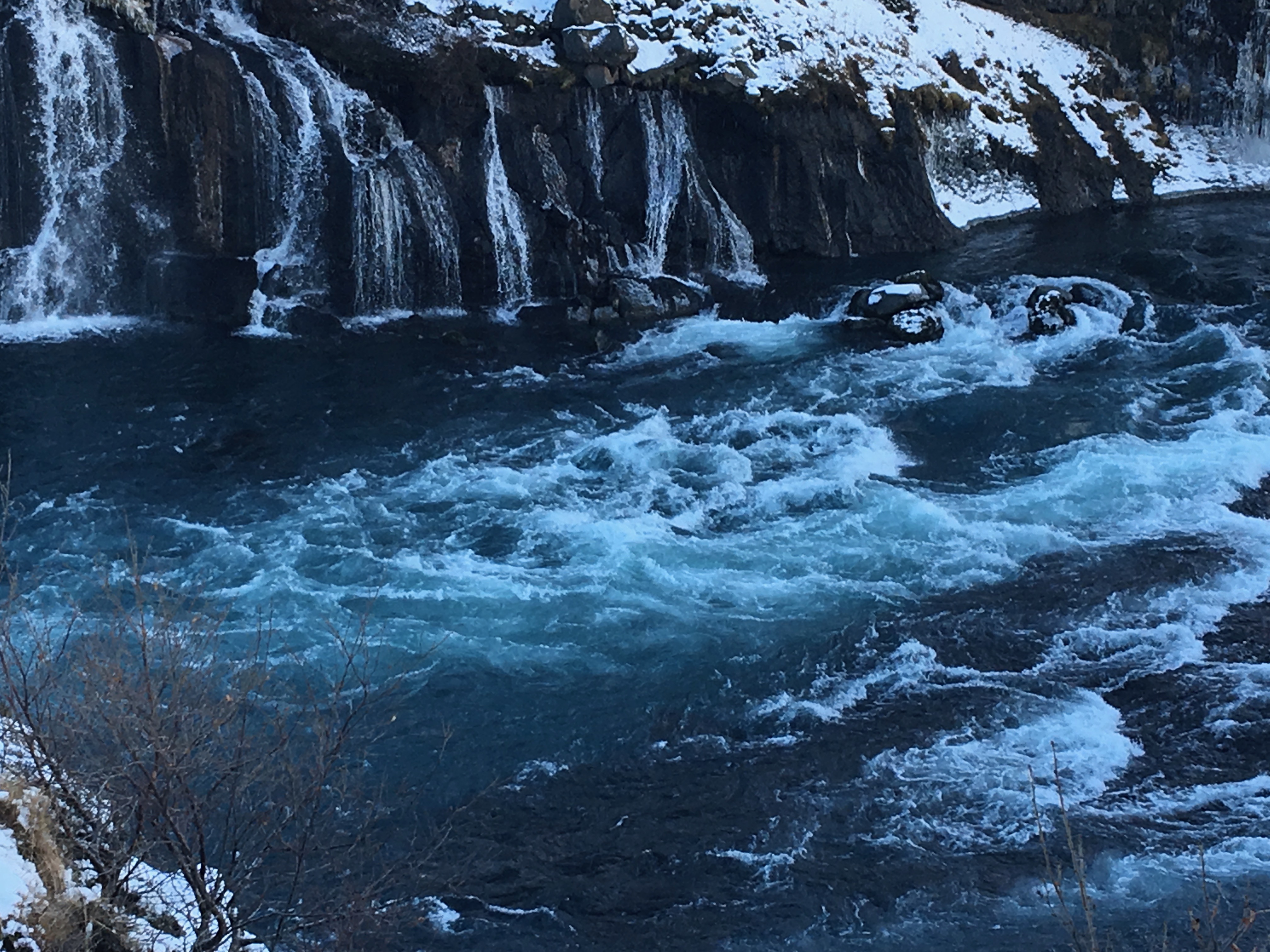 Rushing river with snowy waterfalls